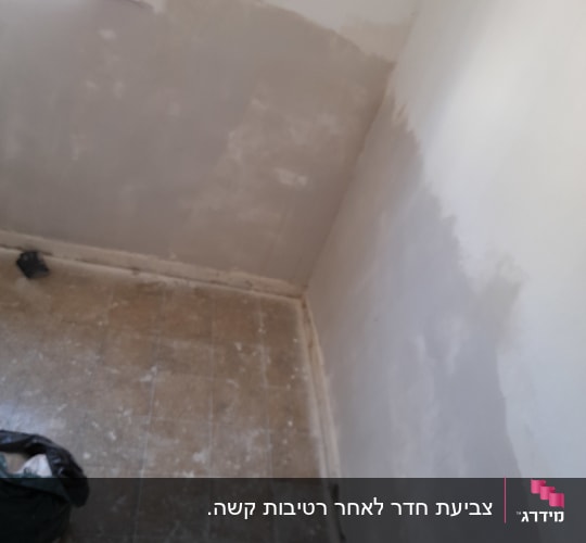 קיר צבוע חלקית בצבע לבן בחדר